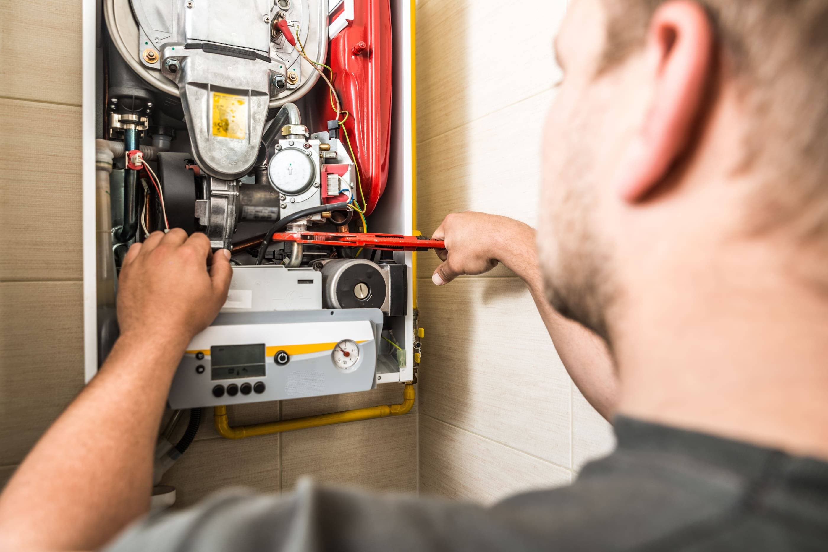 A man working on a hot water heater.