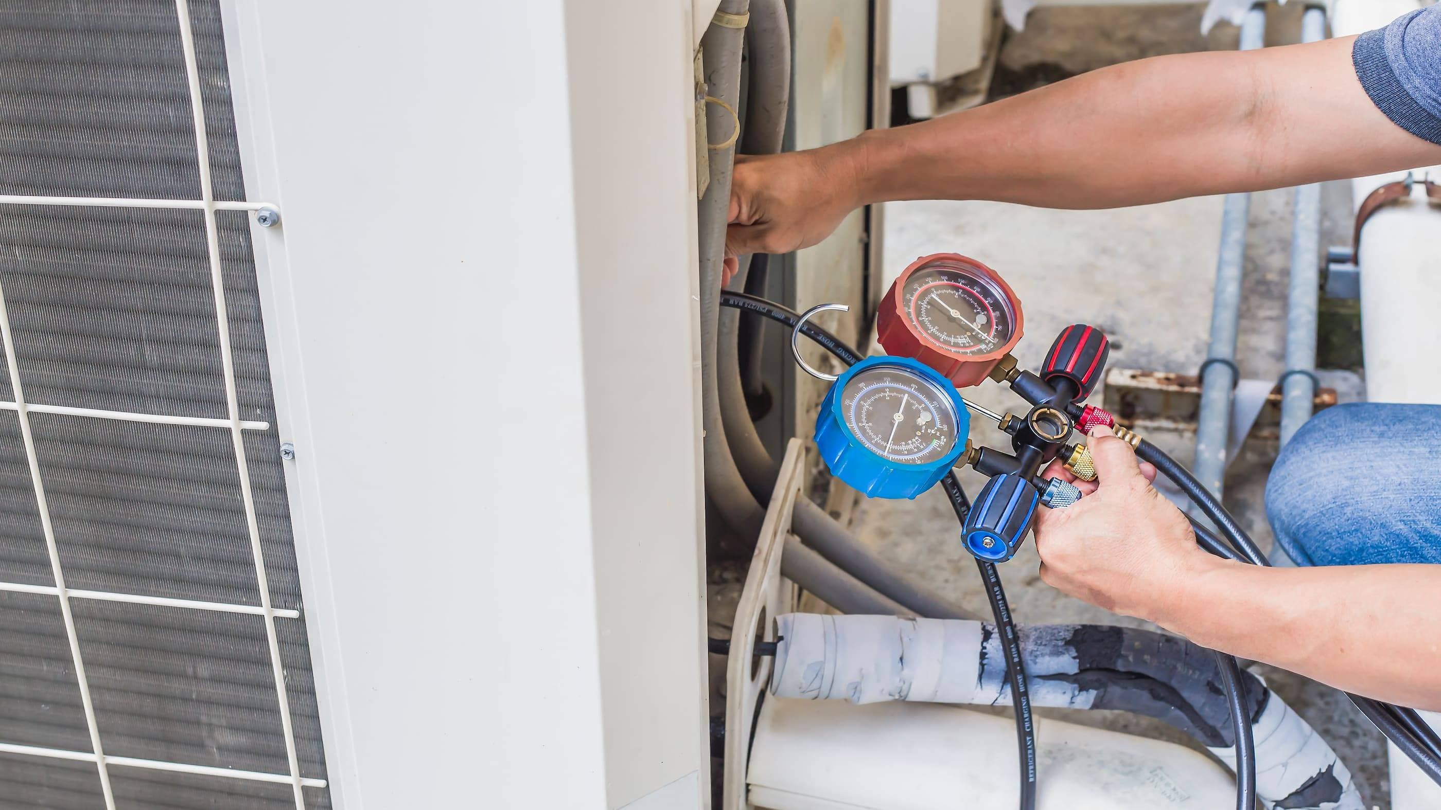 A man is working on an air conditioning unit.