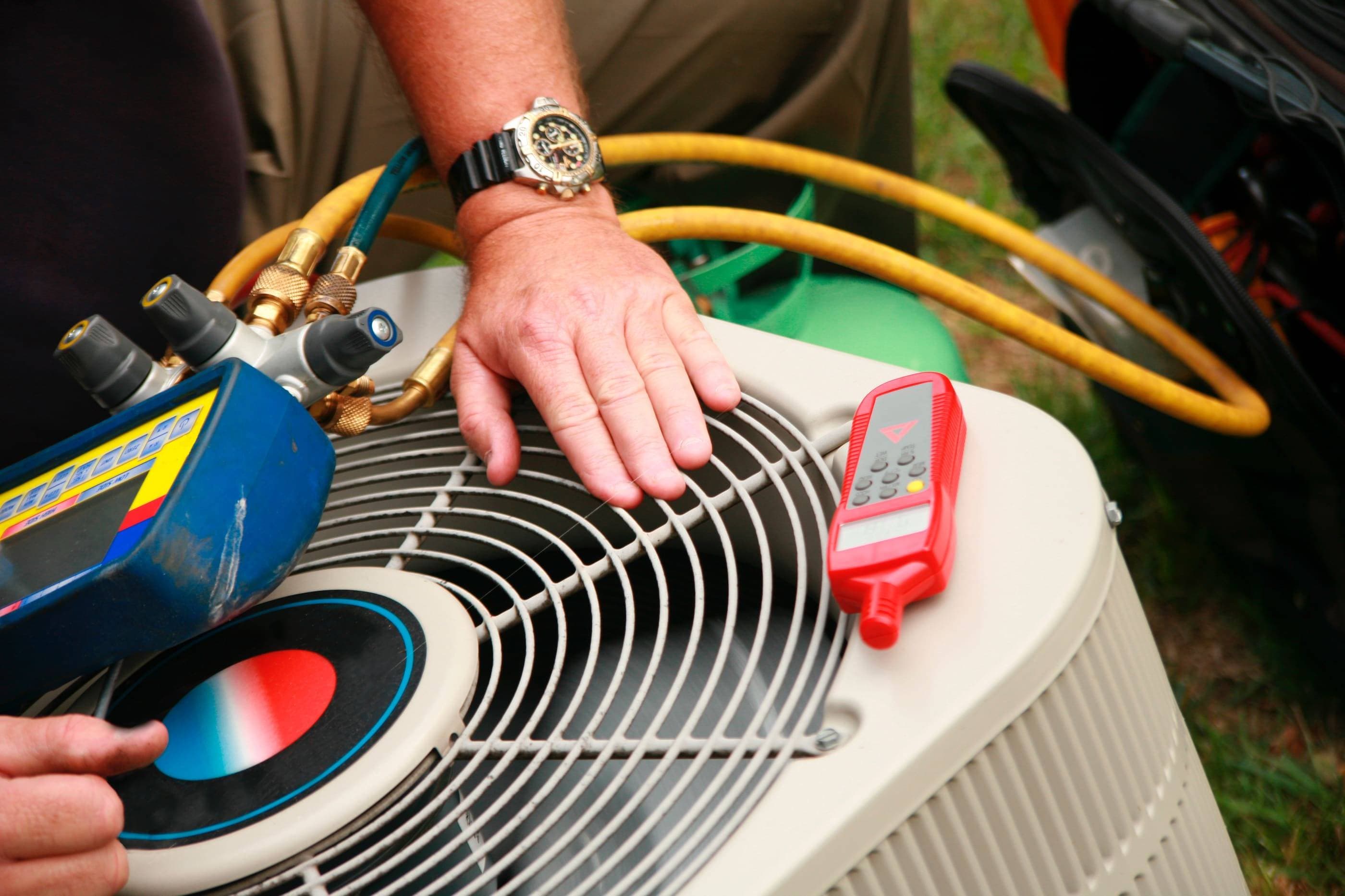 A man is working on an air conditioner.