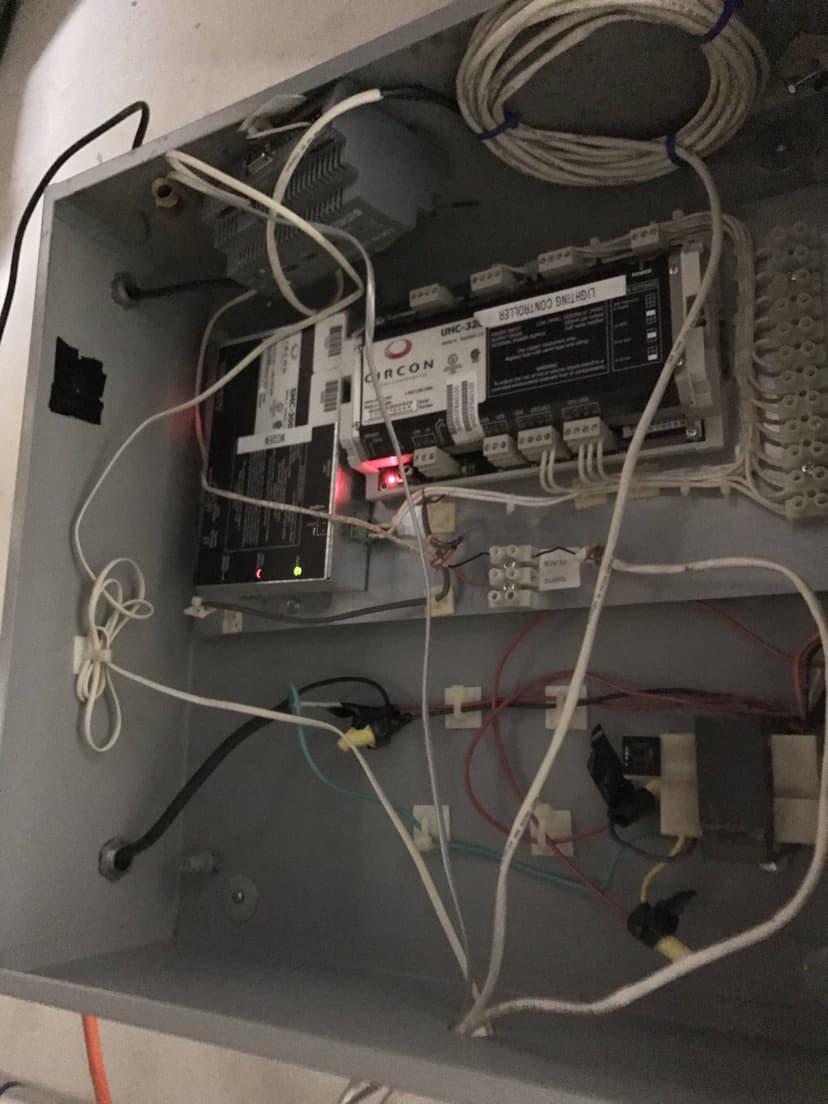 An indoor electrical control panel box with various wires, circuits, and a digital display showing a red light is essential for managing commercial HVAC equipment.