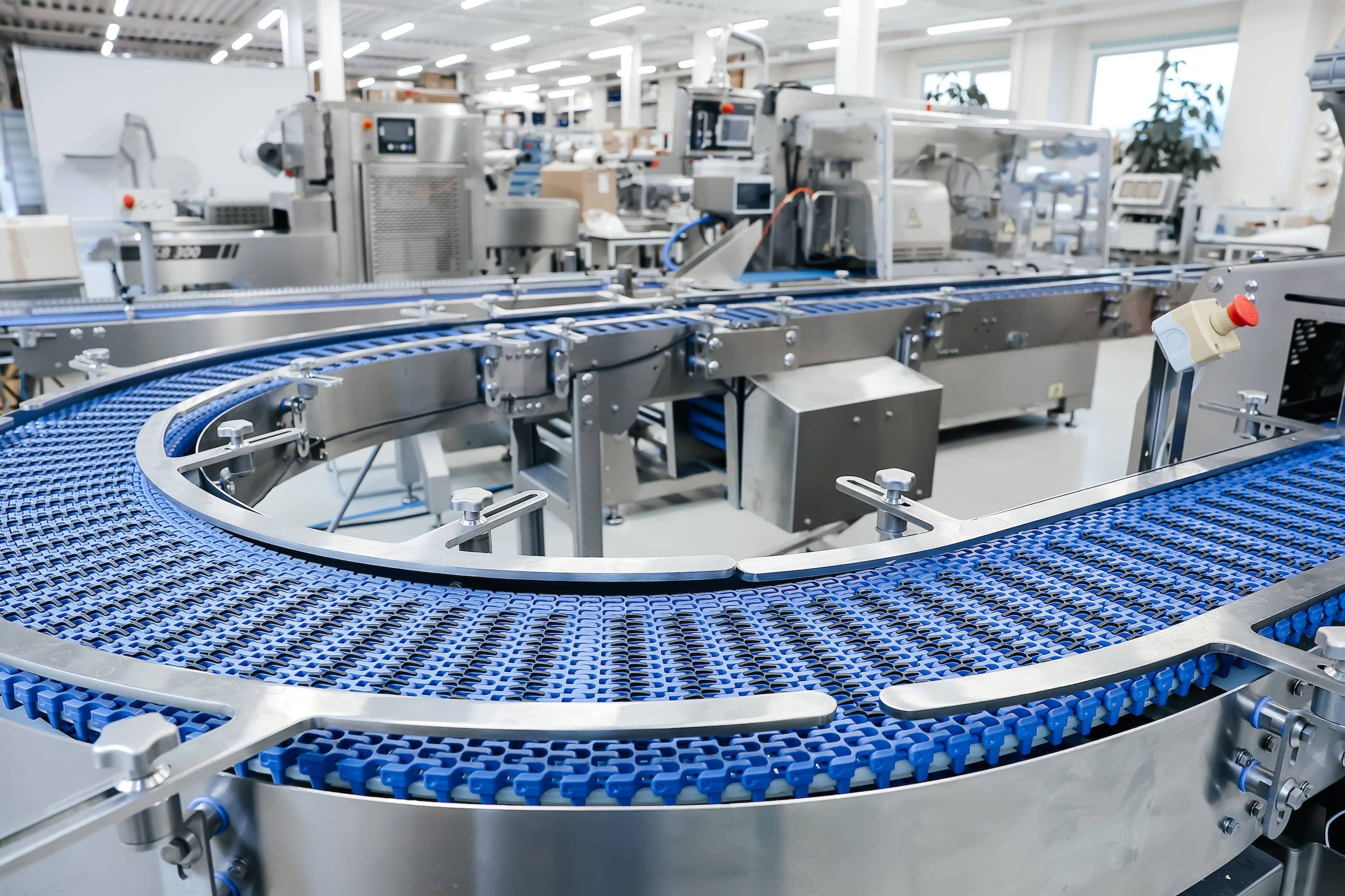 A conveyor belt in a factory with blue belts.