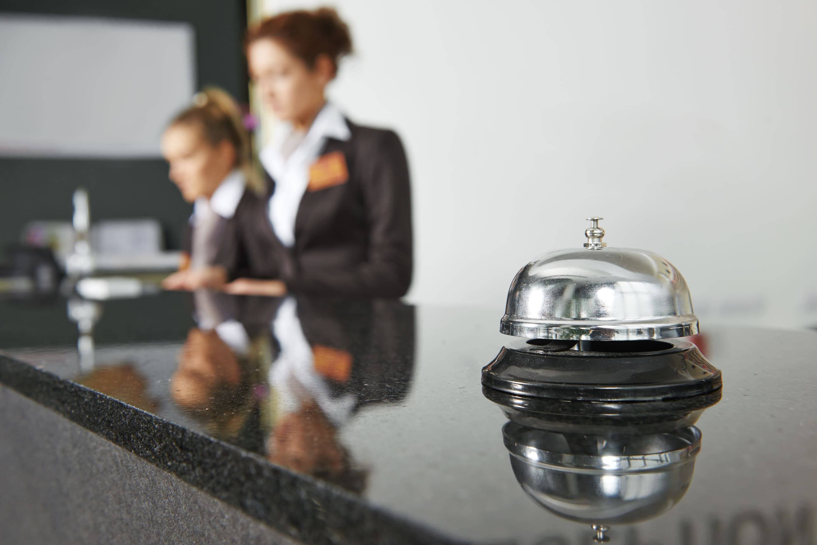 A bell sits on top of a counter in a hotel.