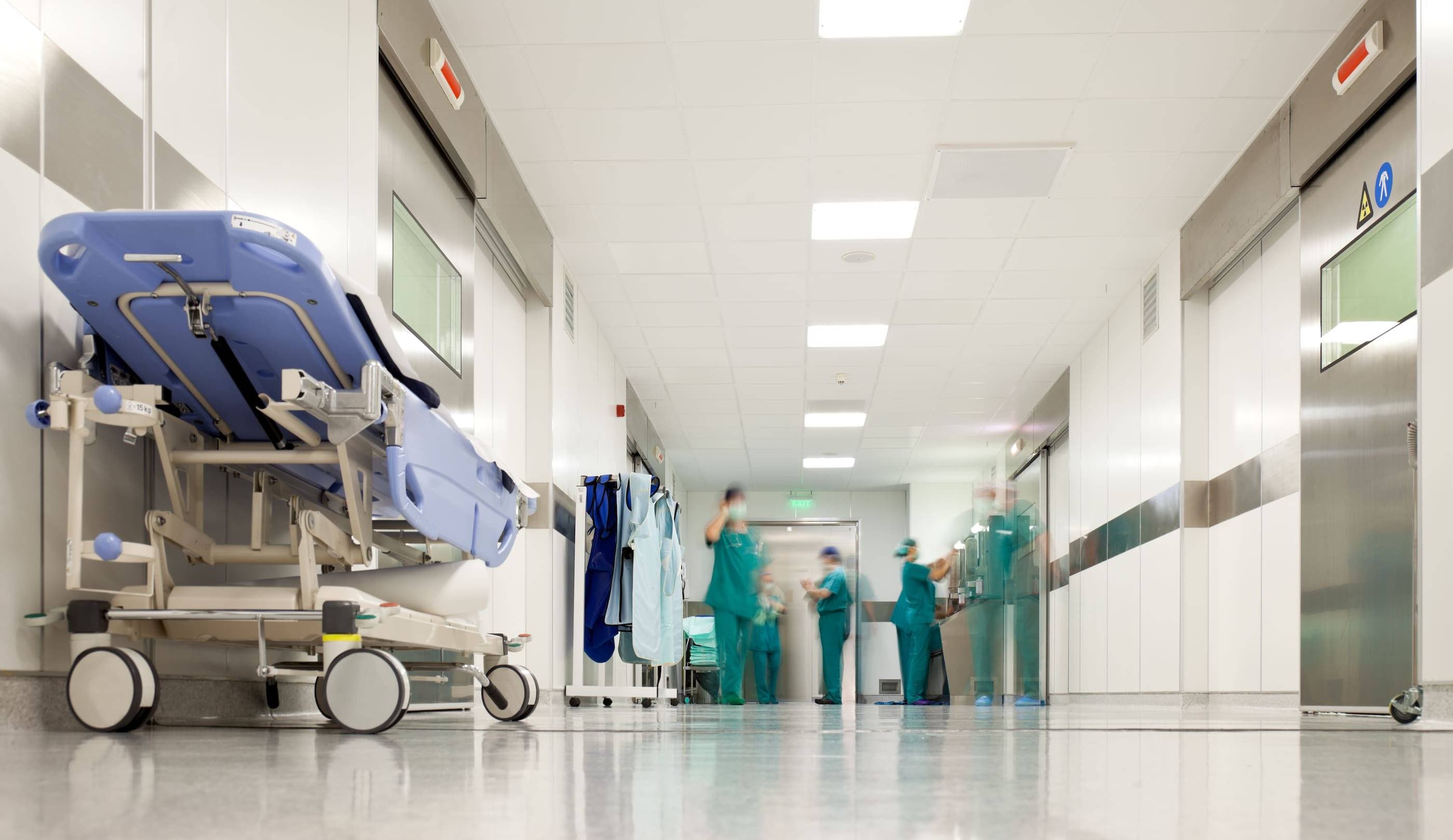 A hospital corridor with a hospital bed and medical equipment.