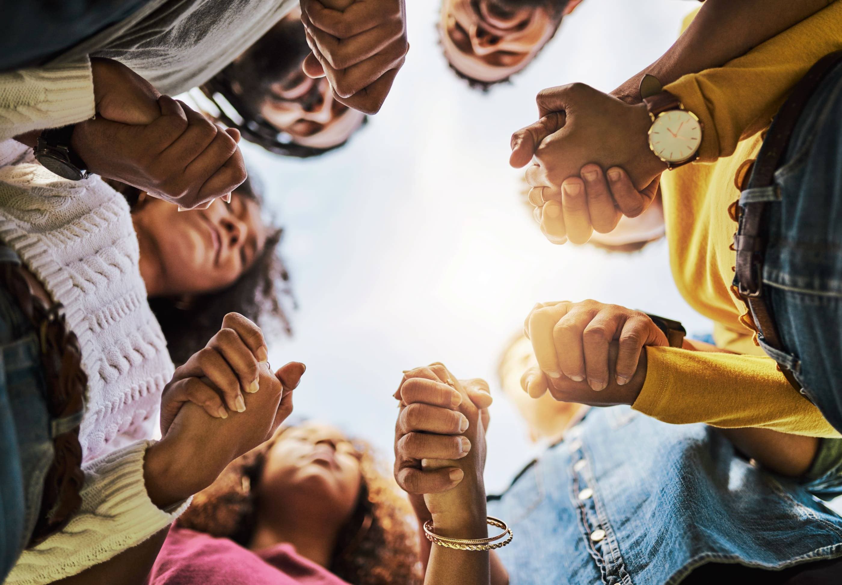 A group of people holding hands in a circle.