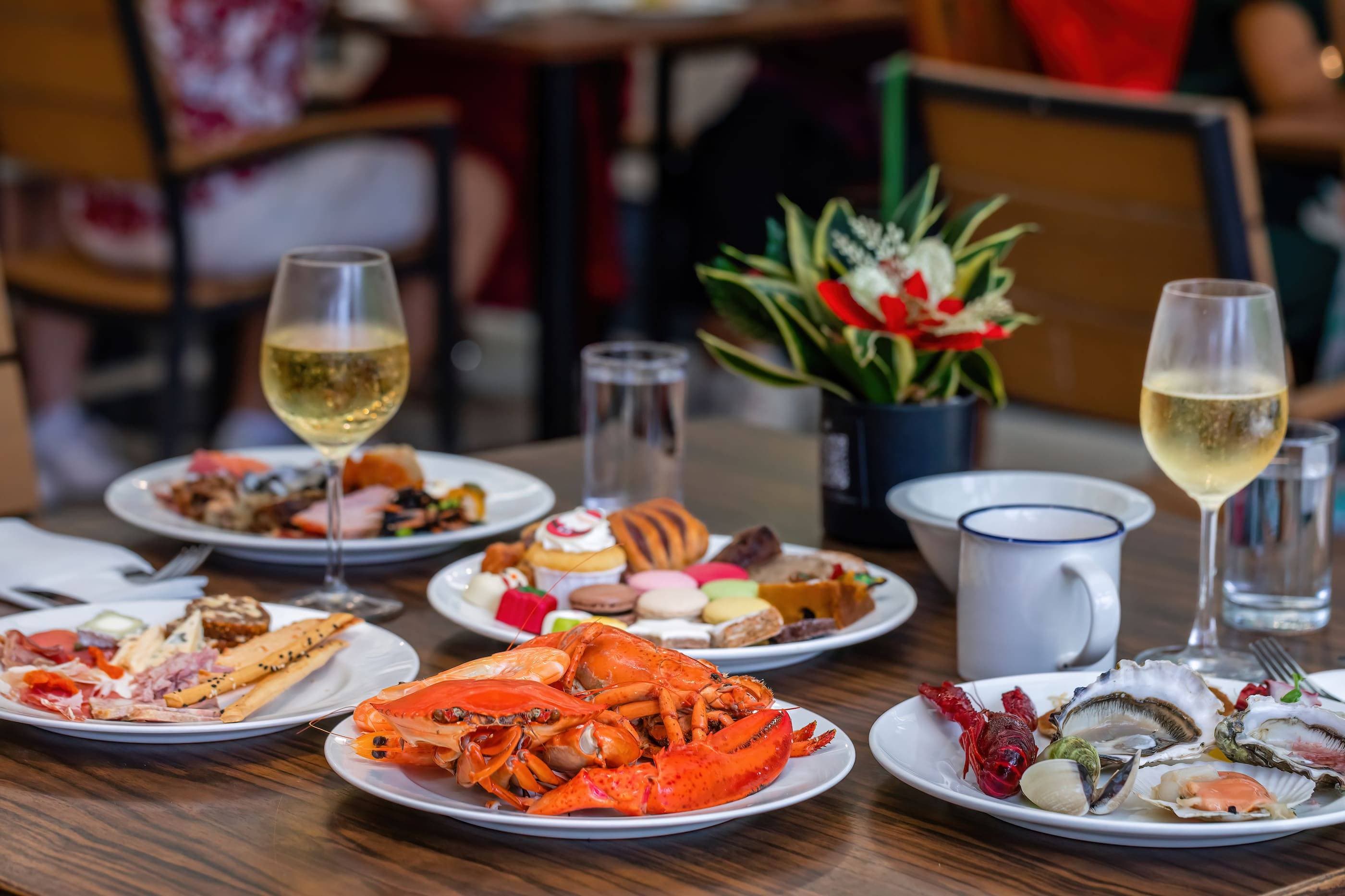 A table with plates of food and glasses of wine.