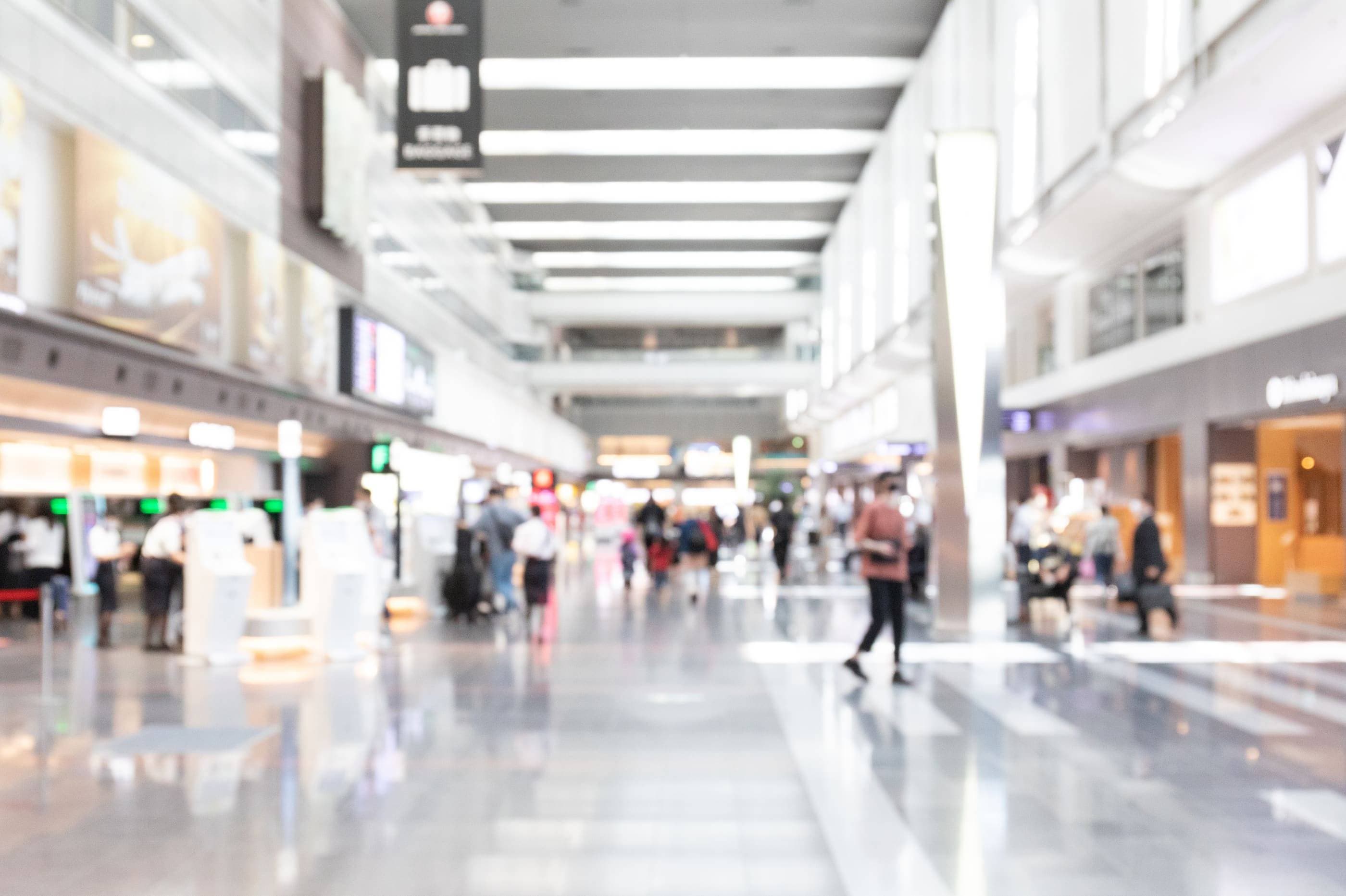 A blurry image of people walking in an airport.