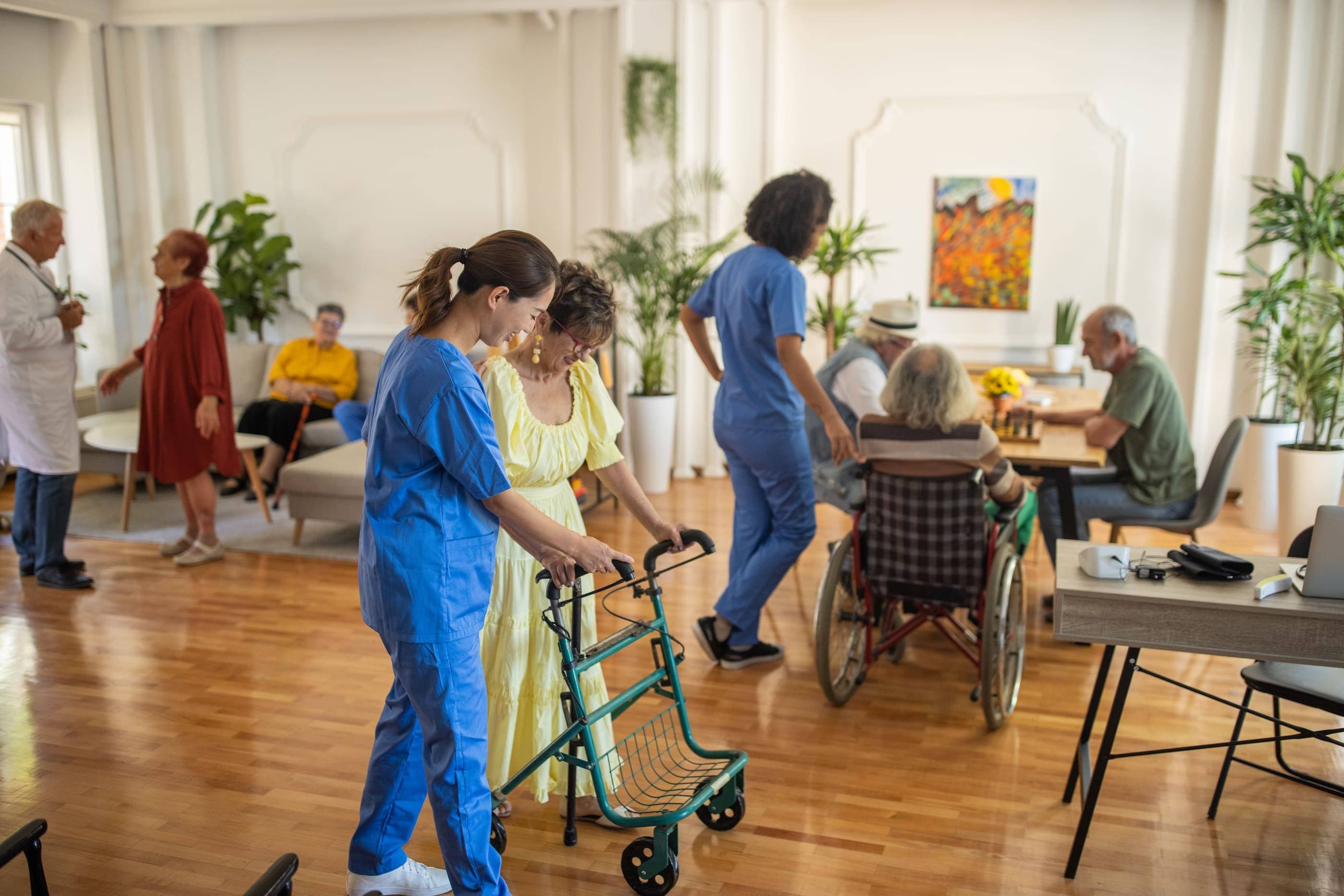 A group of people in a room with a walker.