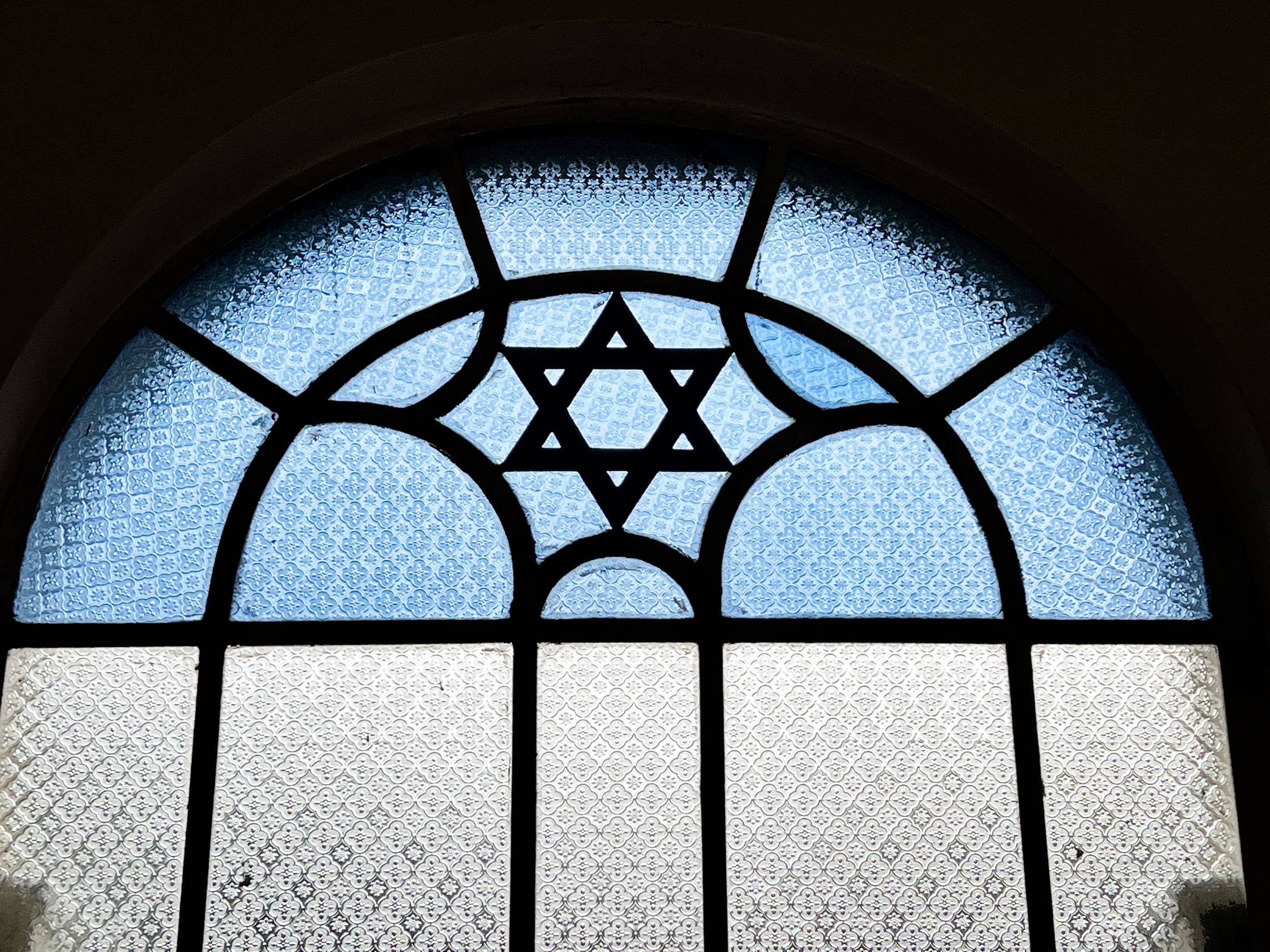 A stained glass window with a star of david.