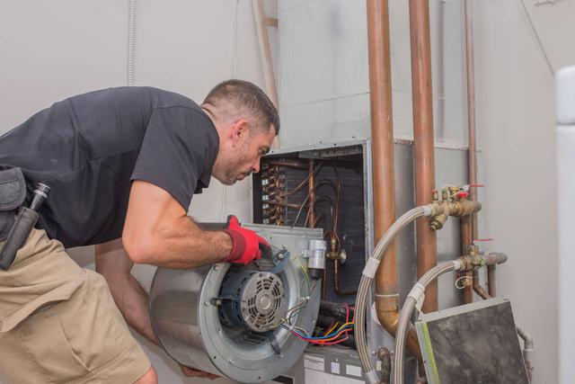 A man working on an air conditioning unit.