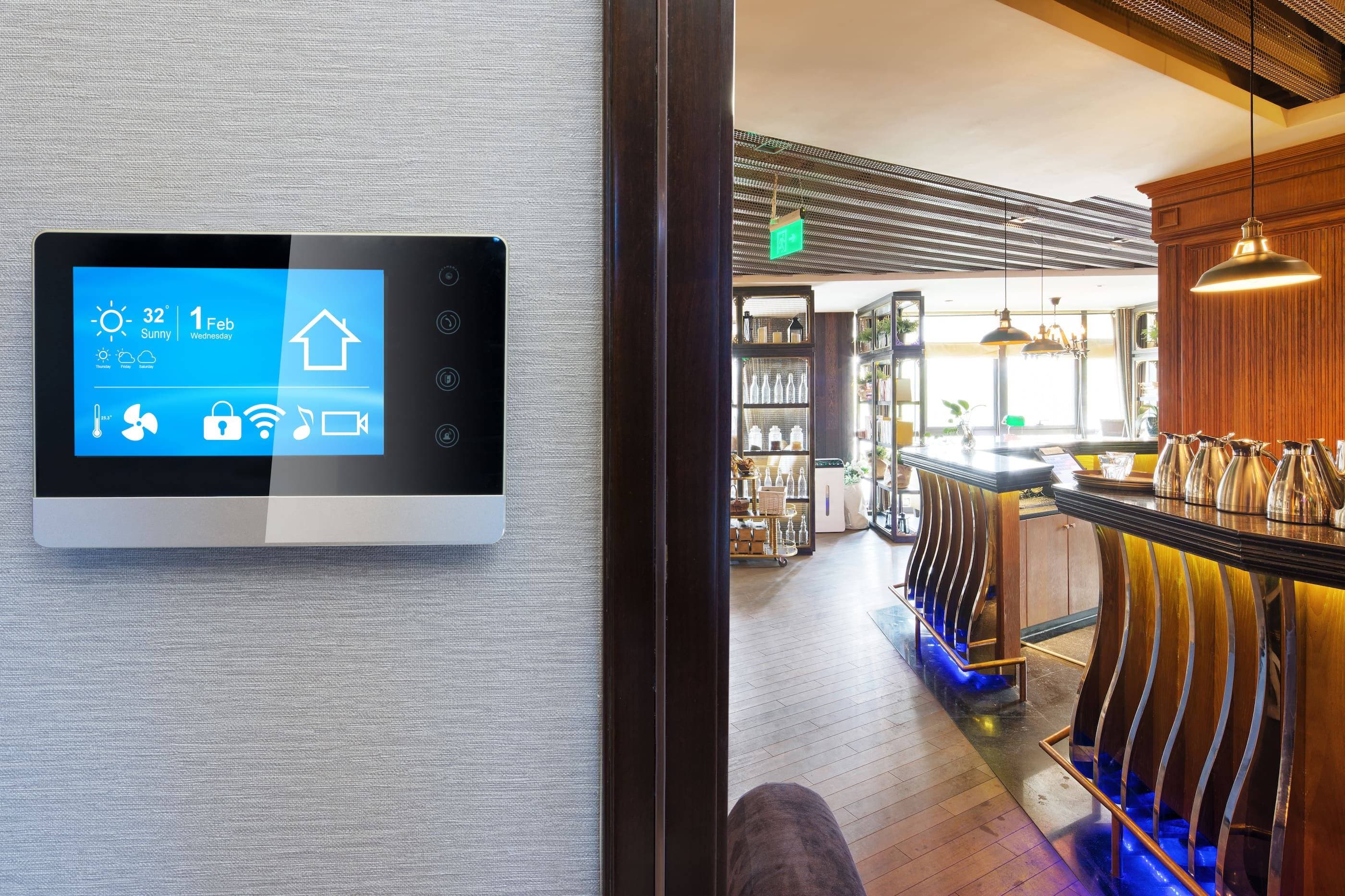 A smart thermostat is mounted on a wall in a restaurant.