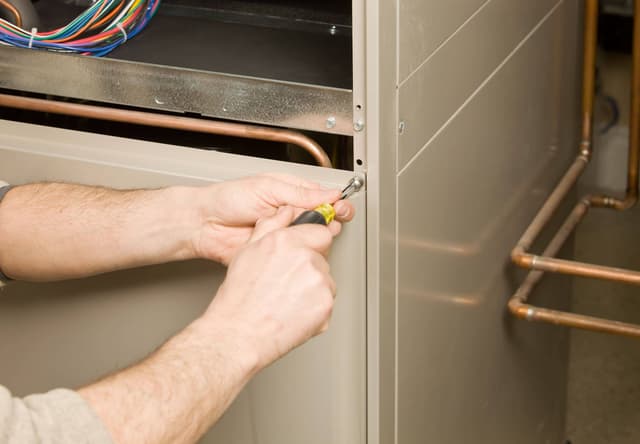 A man working on a gas furnace.