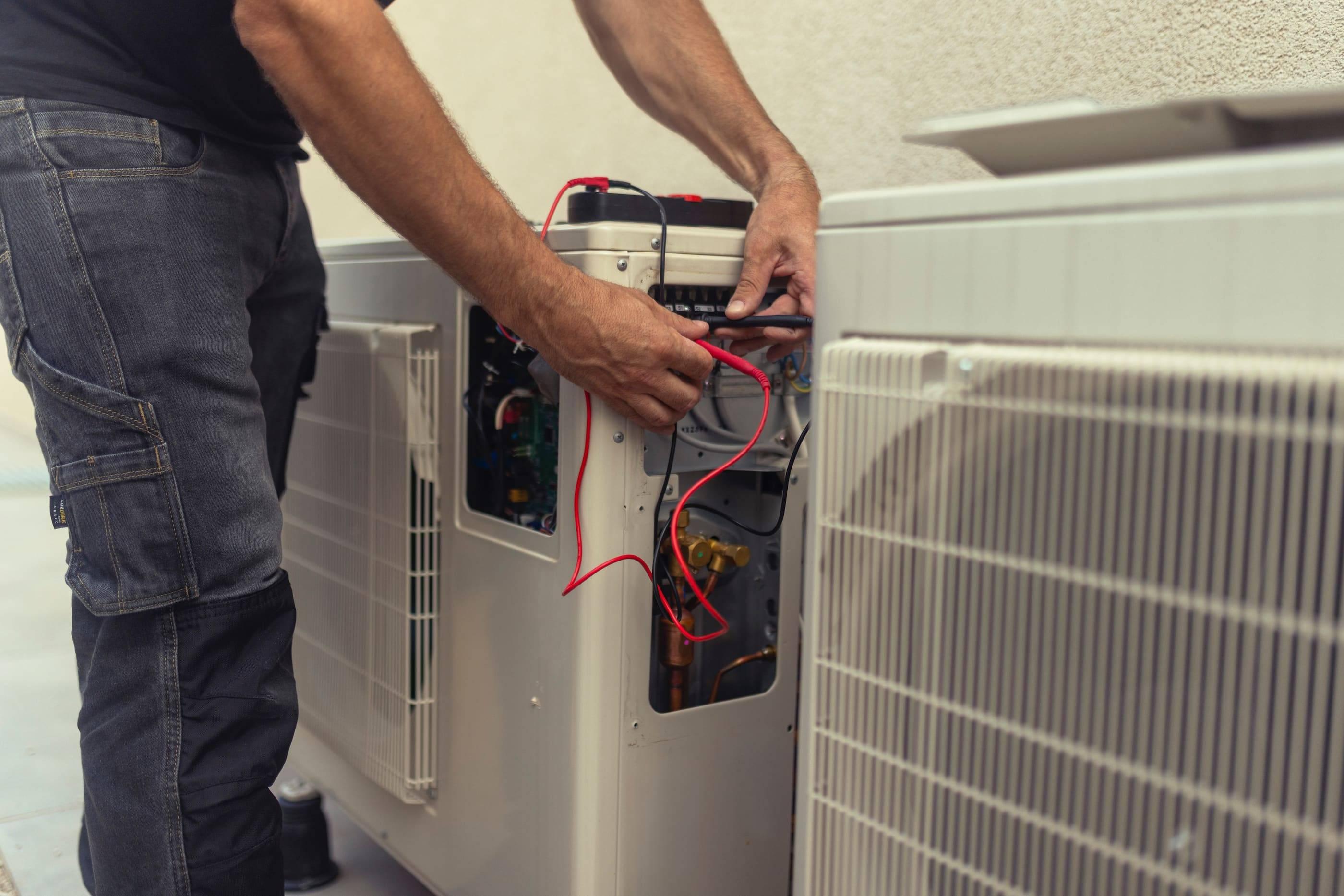 Mechanic repairing heat pump in facility