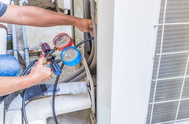 A man is working on an air conditioning unit.