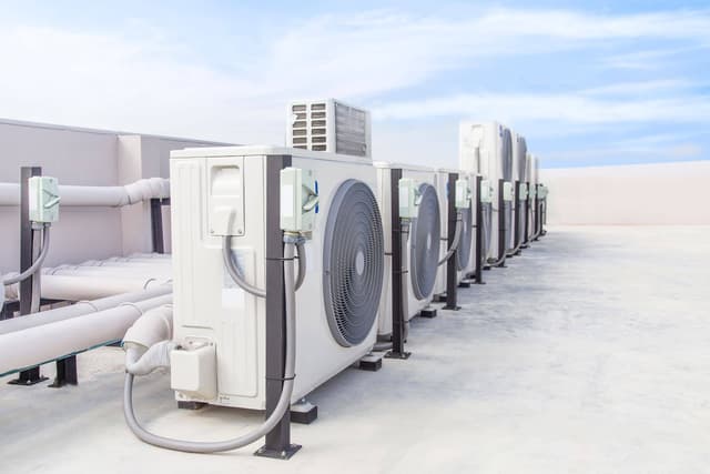 A row of air conditioners on a roof.