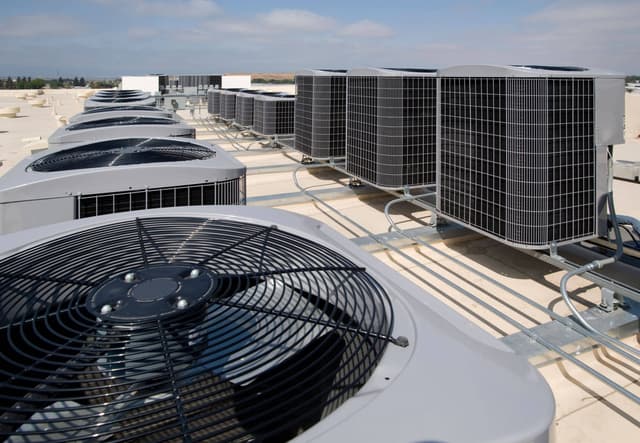 A group of air conditioners on a roof.