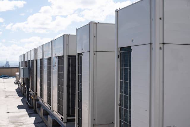 A row of air conditioners on a roof.