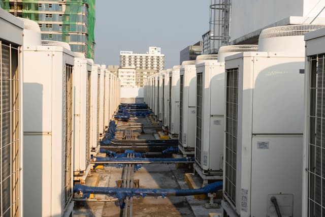 A row of air conditioners in front of a building.